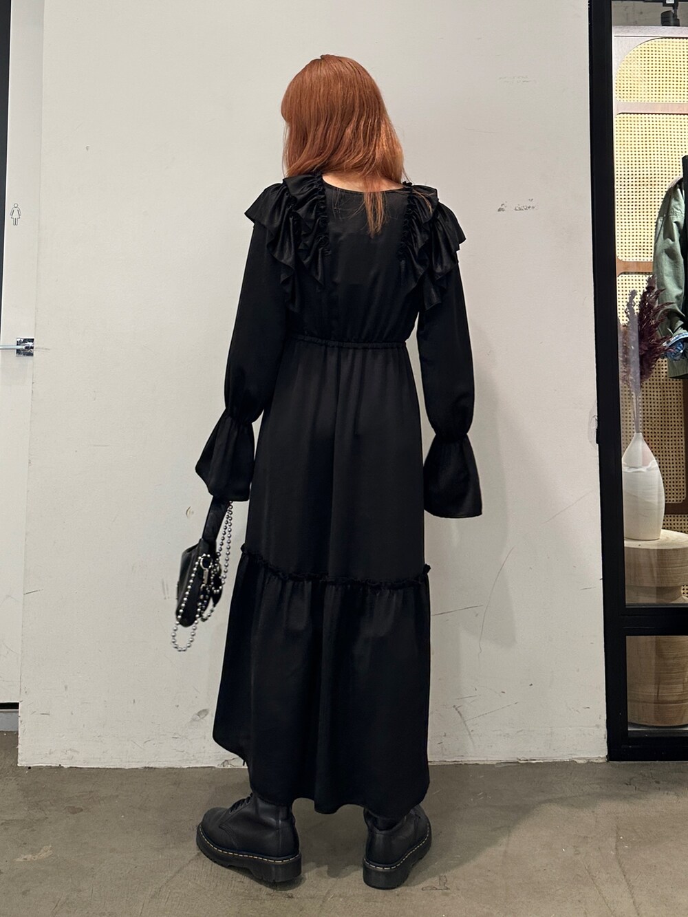 ブラック系のワンピース、ブラック系のハンドバッグ、ブラック系のブーツを着用したレディースの秋コーディネートの3枚目の写真