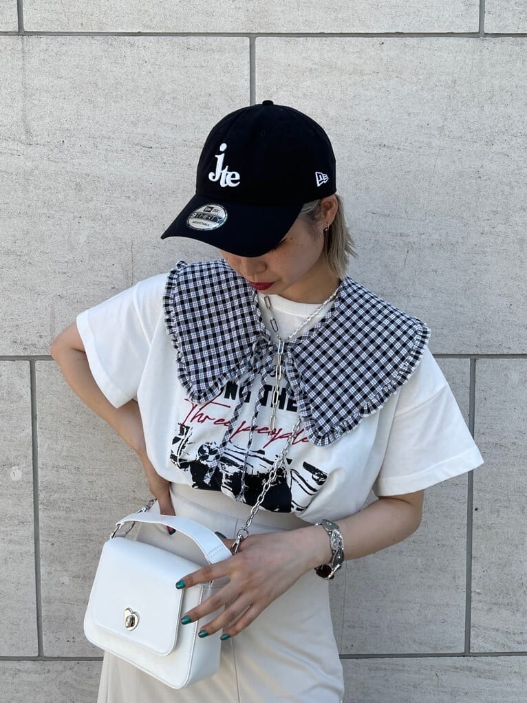 ブラック系のブーツ、ホワイト系のハンドバッグ、ホワイト系のTシャツ/カットソーを着用したレディースの夏コーディネートの4枚目の写真