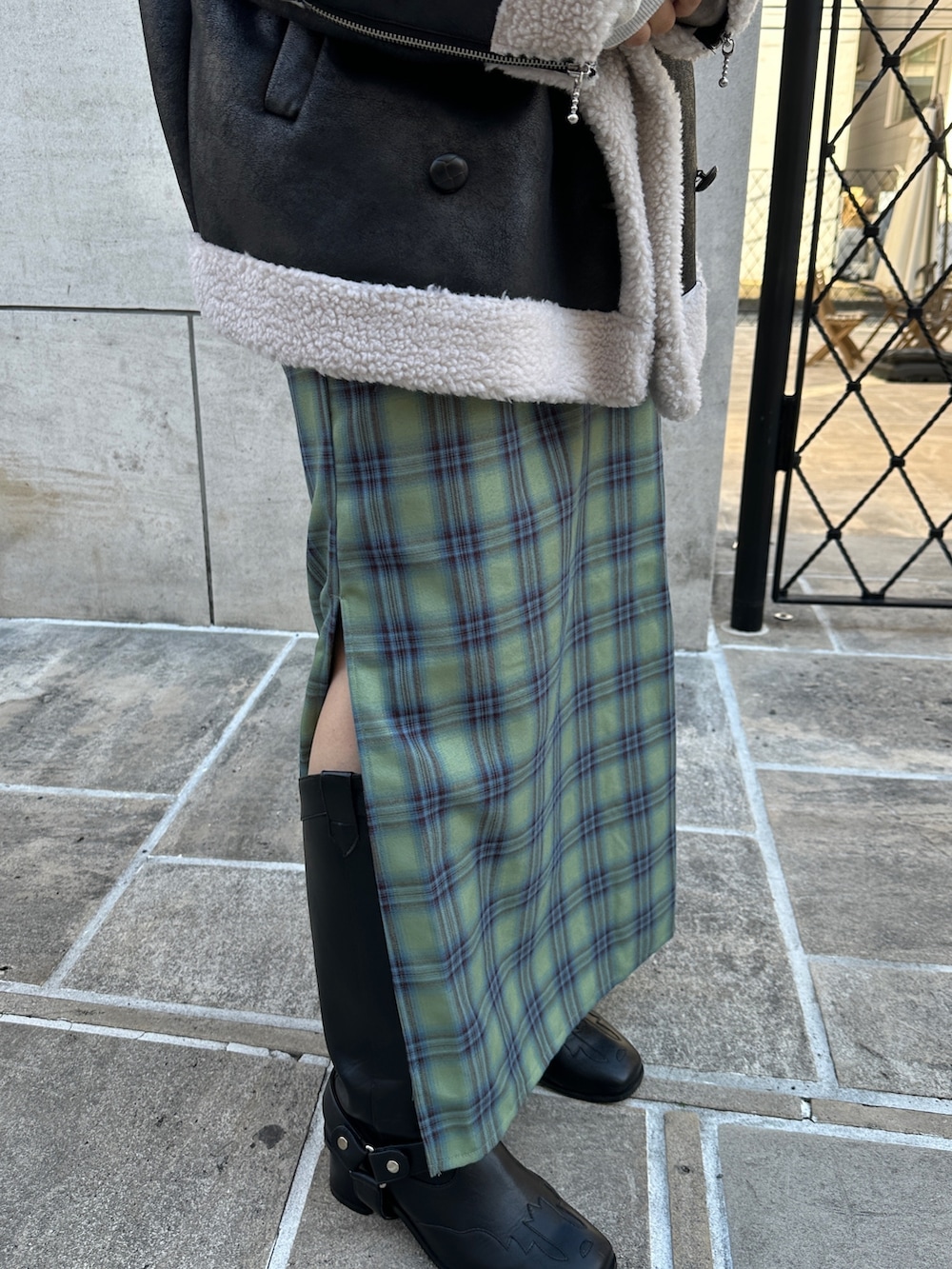 ブラック系のムートンコート、グレー系のスウェット、グリーン系のワンピースを着用したレディースの冬コーディネートの8枚目の写真