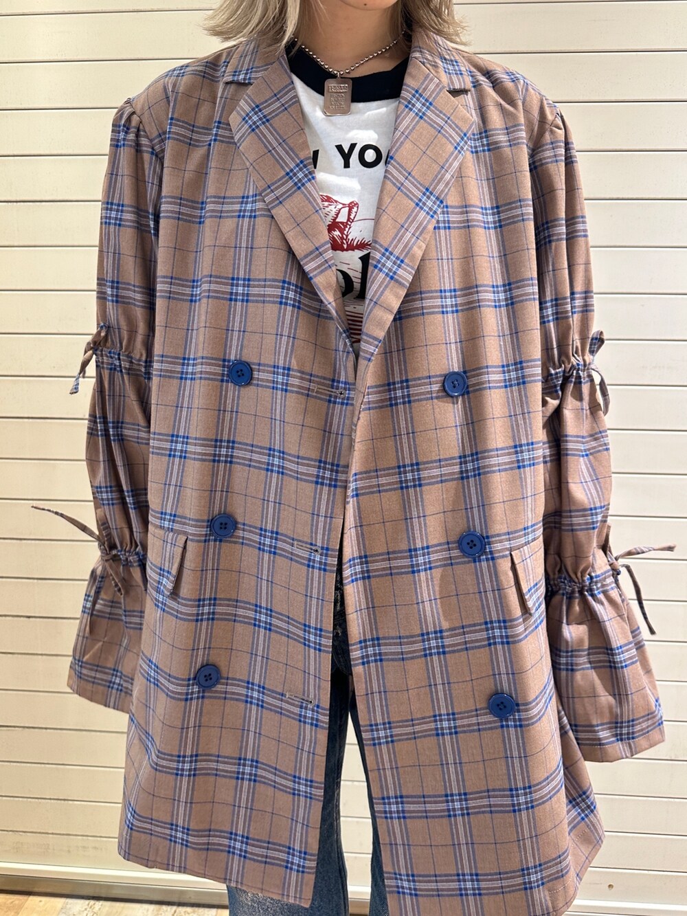 ベージュ系のワンピース、ホワイト系のTシャツ/カットソー、ブルー系のデニムパンツを着用したレディースの秋コーディネートの8枚目の写真