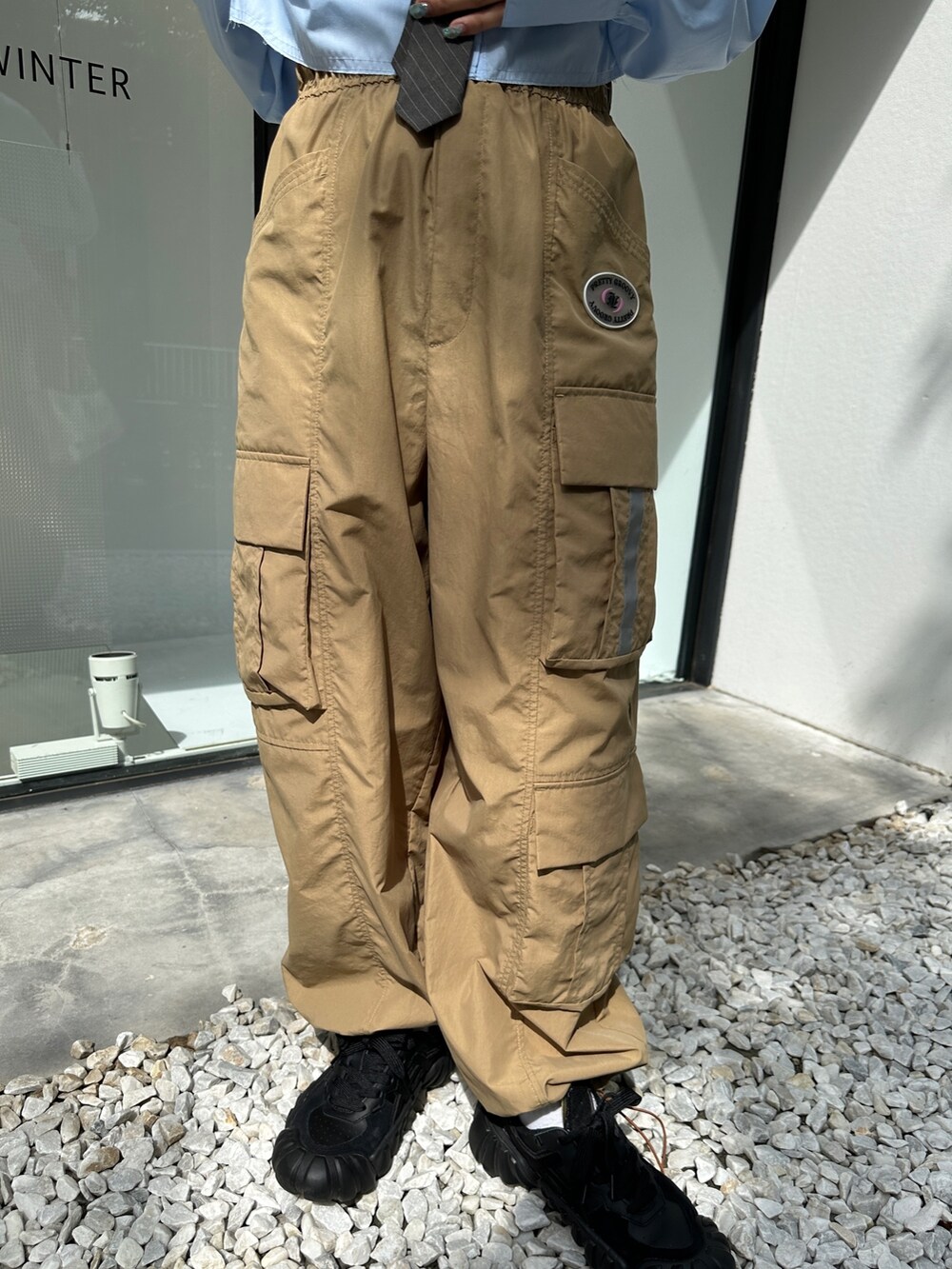 ベージュ系のカーゴパンツ、ブラック系のスニーカー、シルバー系のハンドバッグを着用したレディースの春コーディネートの9枚目の写真