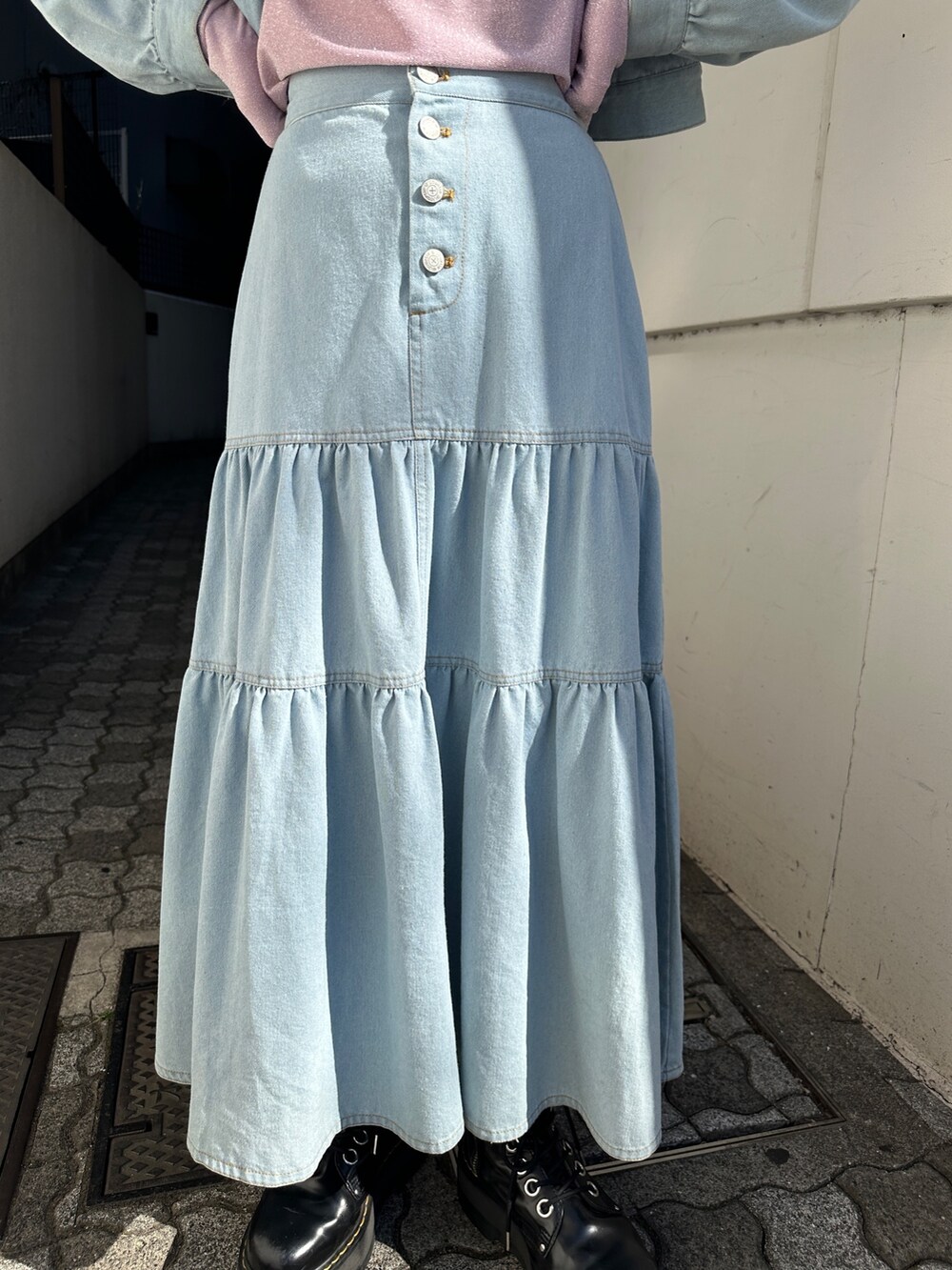 ブルー系のワンピース、ピンク系のTシャツ/カットソー、ブラック系のブーツを着用したレディースの冬コーディネートの9枚目の写真