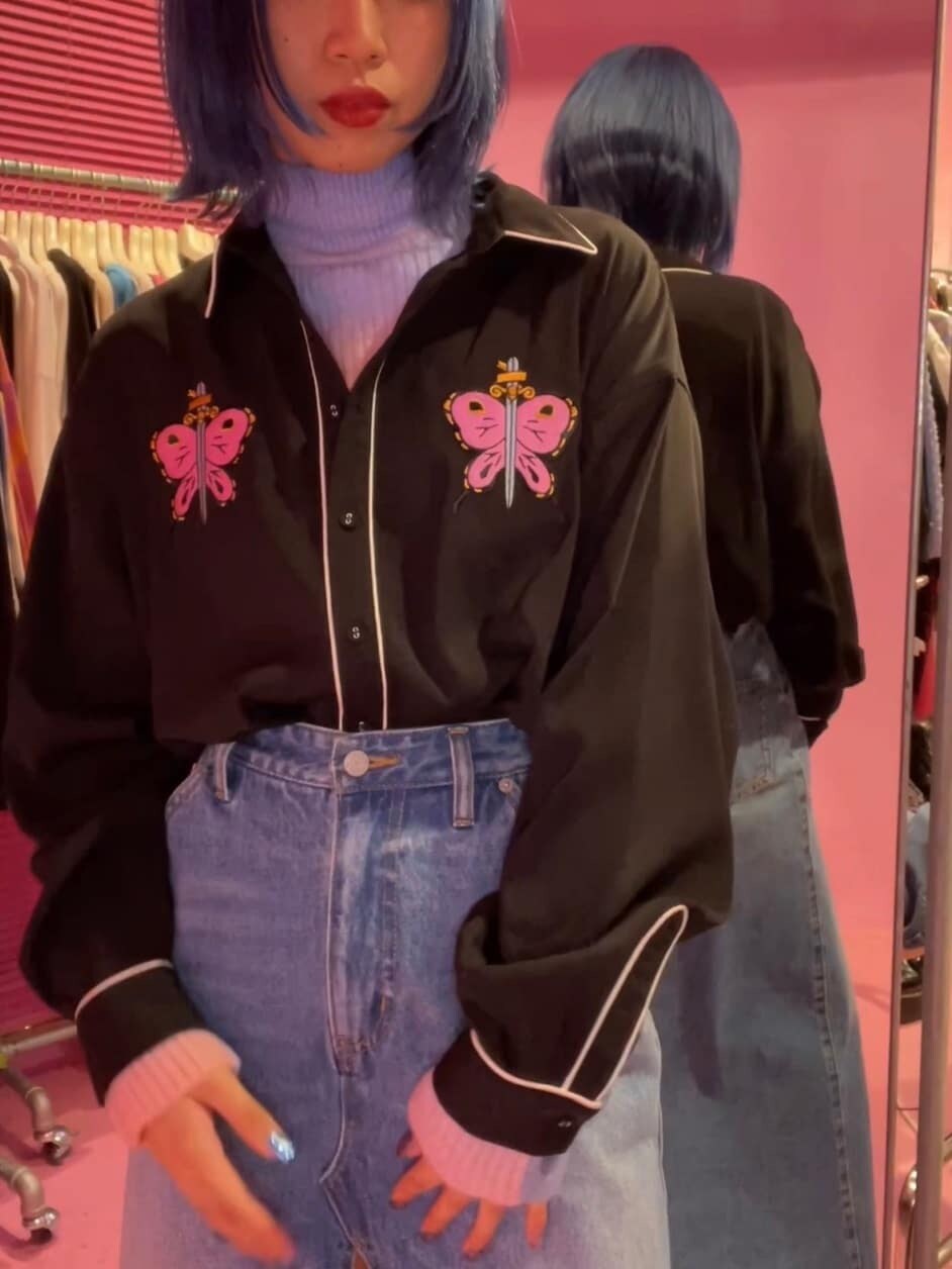 ブルー系のスカート、ブラック系のブーツ、ブラック系のシャツ/ブラウスを着用したレディースの秋コーディネートの3枚目の写真