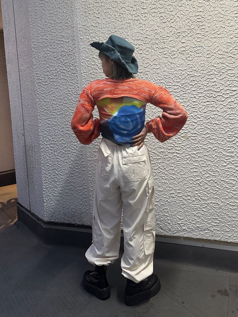 イエロー系のその他パンツ、オレンジ系のニット/セーター、ブラック系のTシャツ/カットソーを着用したレディースの冬コーディネートの4枚目の写真