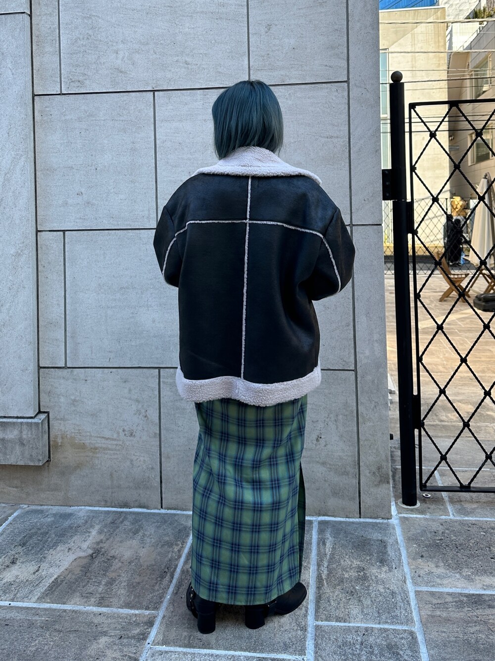 ブラック系のムートンコート、グレー系のスウェット、グリーン系のワンピースを着用したレディースの冬コーディネートの3枚目の写真