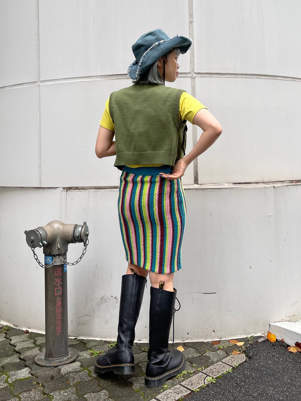 イエロー系のTシャツ/カットソー、グリーン系のベスト、ブルー系のスカートを着用したレディースの春コーディネートの4枚目の写真
