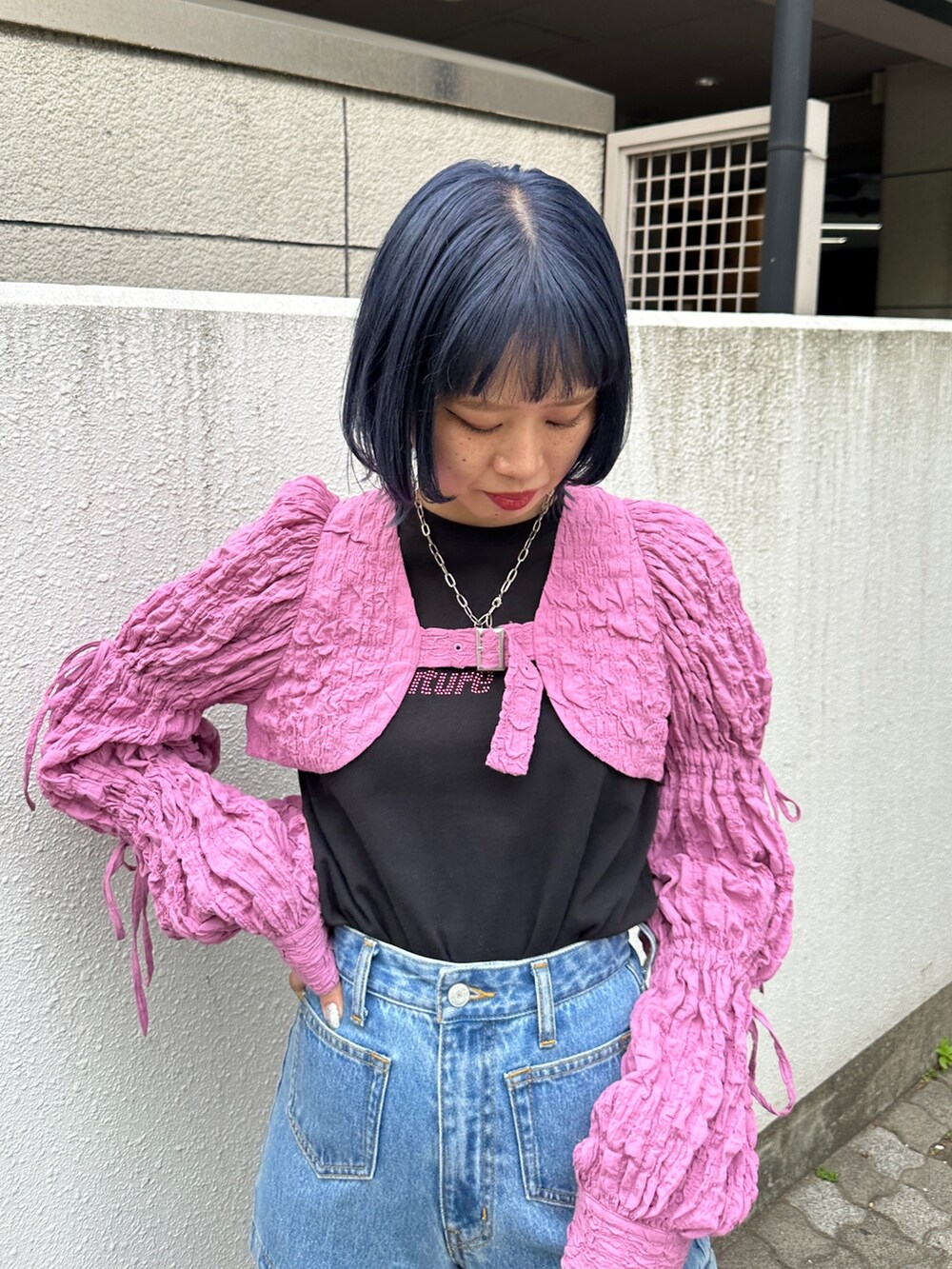 ピンク系のカーディガン/ボレロ、ブラック系のTシャツ/カットソー、ブルー系のデニムパンツを着用したレディースの春コーディネートの5枚目の写真