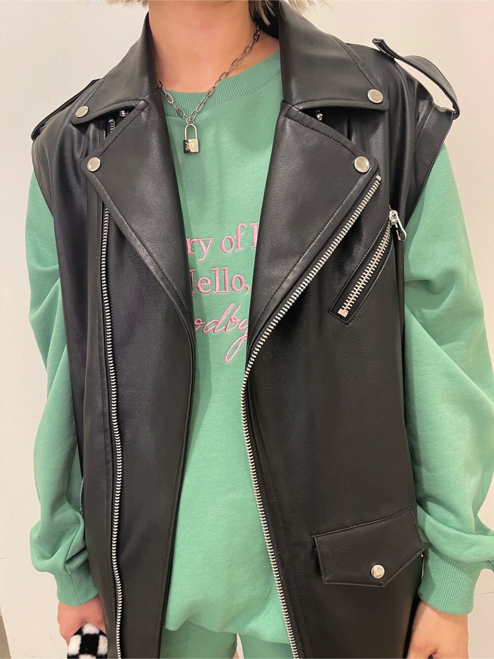 ブラック系のブーツ、ブラック系のボストンバッグ、ブラック系のライダースジャケットを着用したレディースの夏コーディネートの6枚目の写真