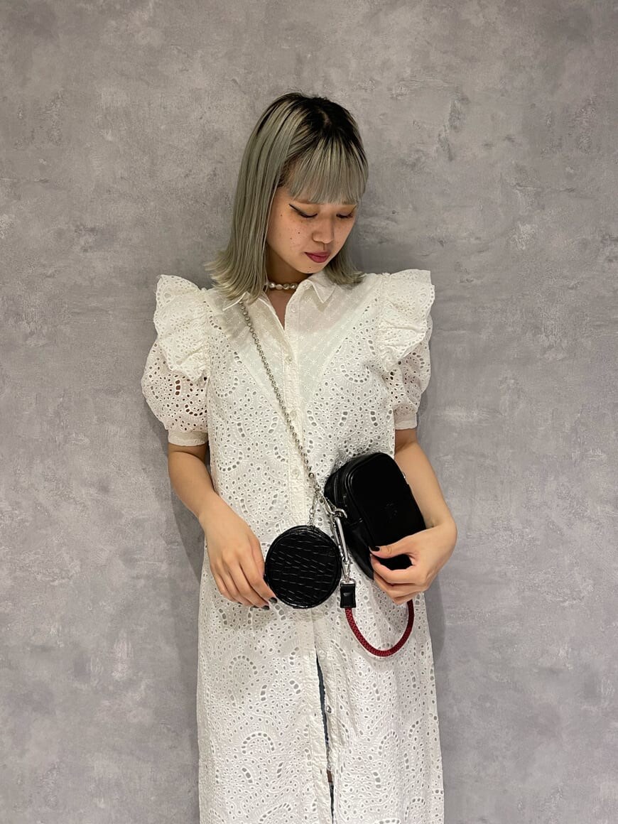 ホワイト系のワンピース、ブルー系のデニムパンツ、ブラウン系のショルダーバッグを着用したレディースの夏コーディネートの5枚目の写真