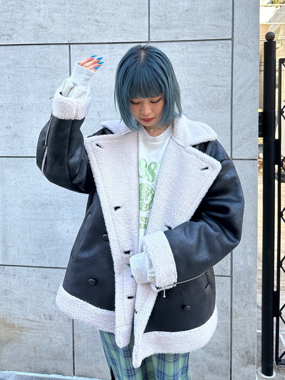 ブラック系のムートンコート、グレー系のスウェット、グリーン系のワンピースを着用したレディースの冬コーディネートの4枚目の写真