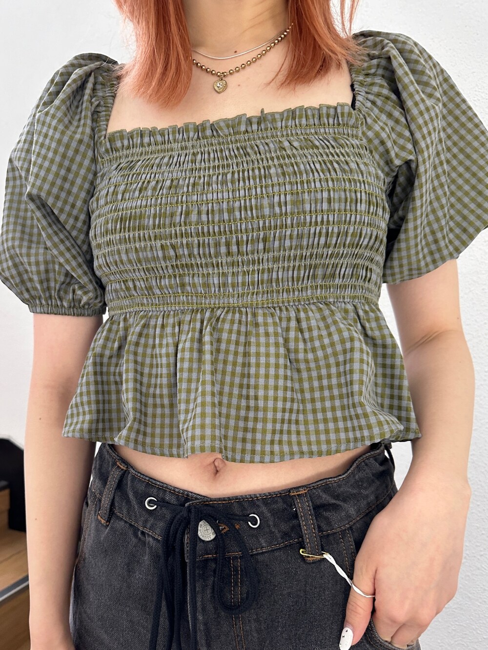 ブラック系のデニムパンツ、グリーン系のシャツ/ブラウス、ブラック系のブーツを着用したレディースの冬コーディネートの5枚目の写真