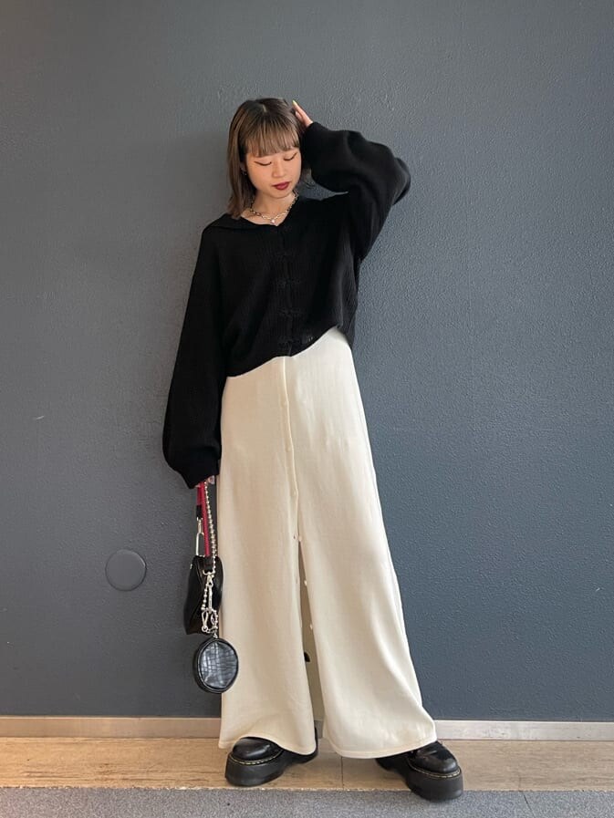 ブラック系のショルダーバッグ、ホワイト系のワンピース、ブラック系のニット/セーターを着用したレディースの秋コーディネートの3枚目の写真