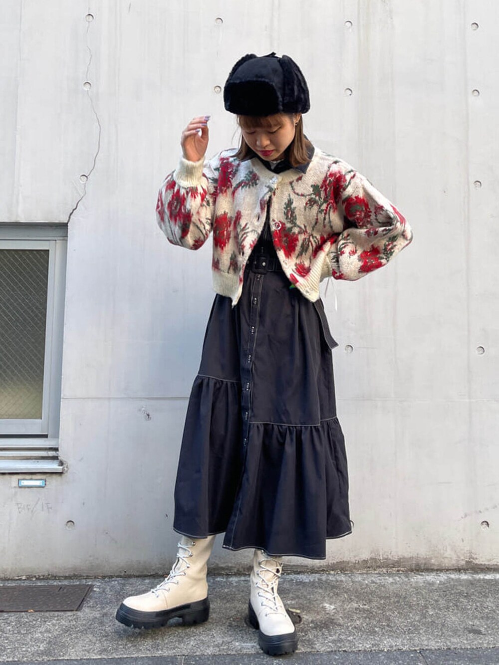 ホワイト系のブーツ、ブラック系のワンピース、ホワイト系のカーディガン/ボレロを着用したレディースの冬コーディネートの3枚目の写真