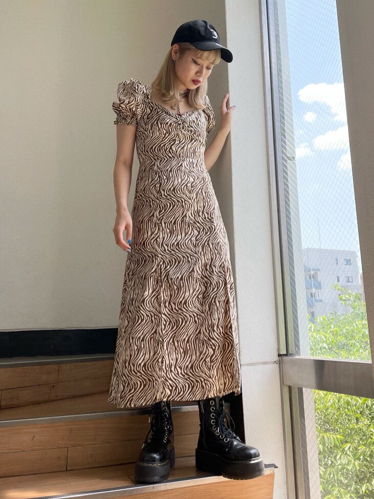 ホワイト系のワンピース、ブラック系のキャップを着用したレディースの春コーディネートの2枚目の写真