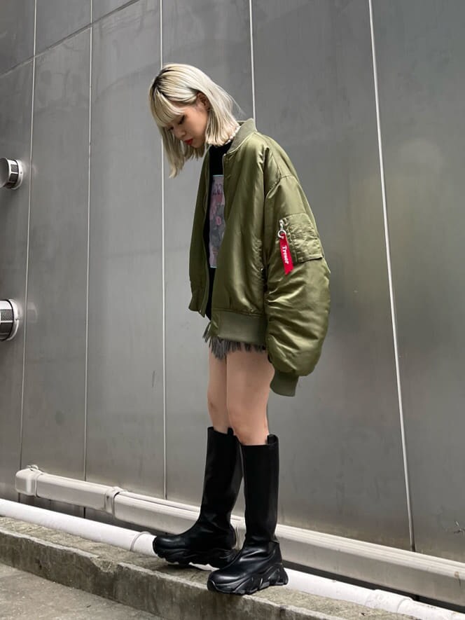 ブラック系のデニムパンツ、ベージュ系のMA-1、ブラック系のブーツを着用したレディースの秋コーディネートの2枚目の写真