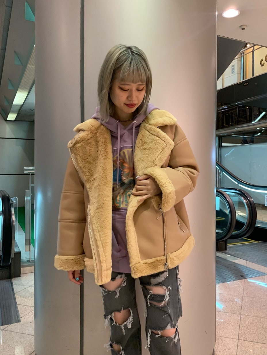 ブラック系のデニムパンツ、ベージュ系のムートンコート、パープル系のパーカーを着用したレディースの秋コーディネートの2枚目の写真