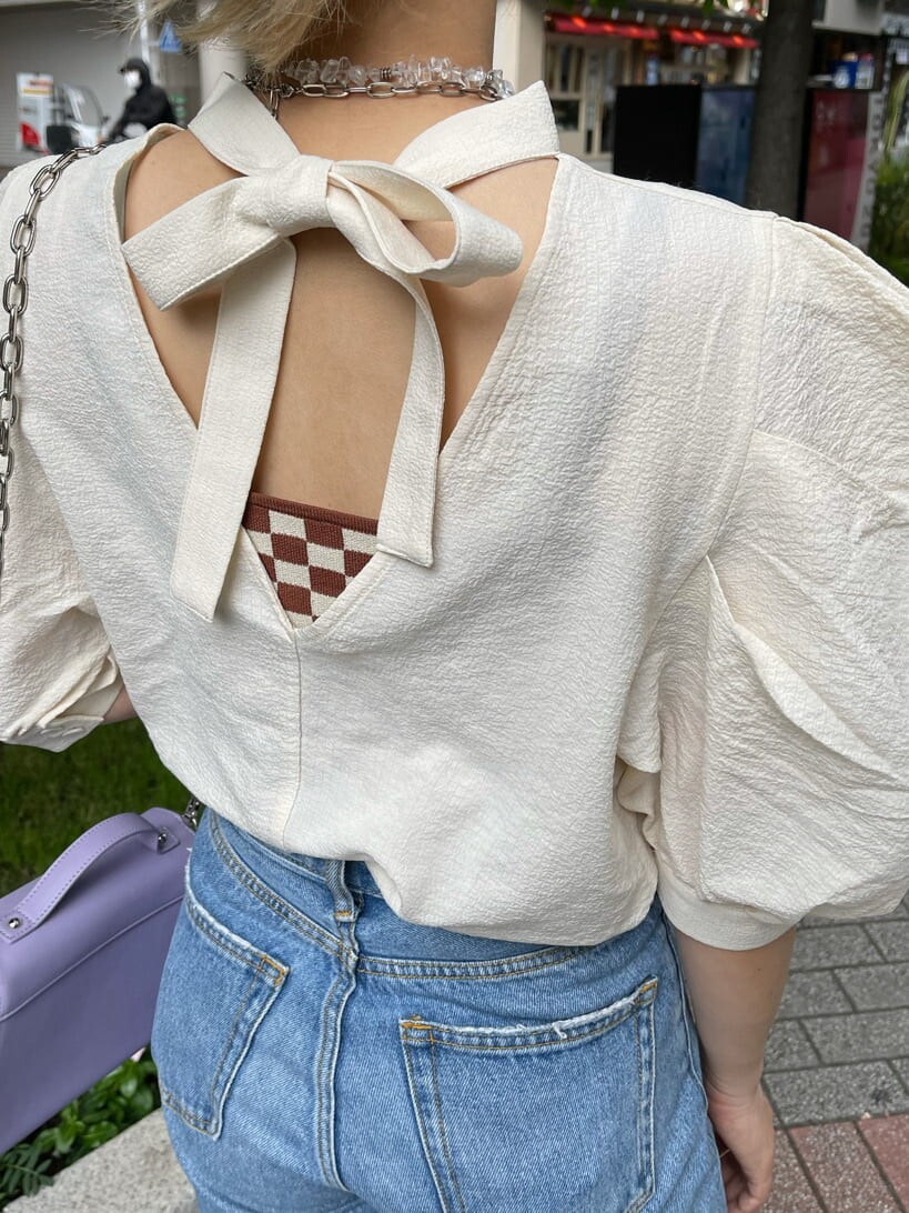 パープル系のショルダーバッグ、ホワイト系のシャツ/ブラウス、ブルー系のデニムパンツを着用したレディースの夏コーディネートの7枚目の写真