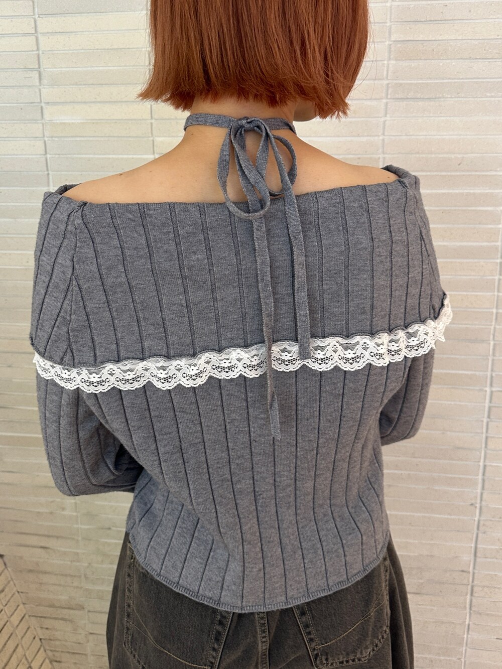 グレー系のニット/セーター、ブラック系のデニムパンツ、ブラック系のブーツを着用したレディースの冬コーディネートの10枚目の写真