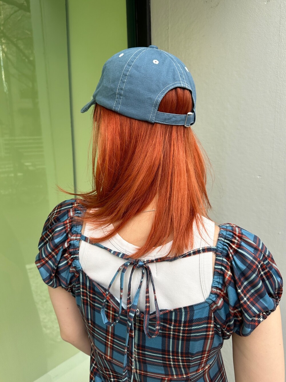 ブルー系のワンピース、ブラック系のスニーカー、ブルー系のキャップを着用したレディースの春コーディネートの9枚目の写真