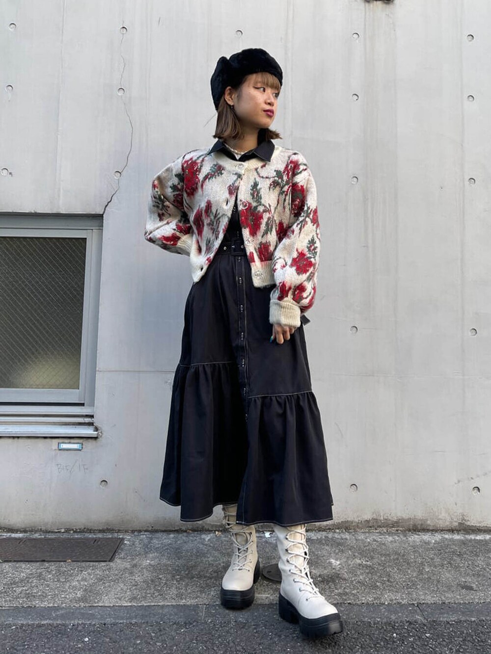 ホワイト系のブーツ、ブラック系のワンピース、ホワイト系のカーディガン/ボレロを着用したレディースの冬コーディネートの2枚目の写真