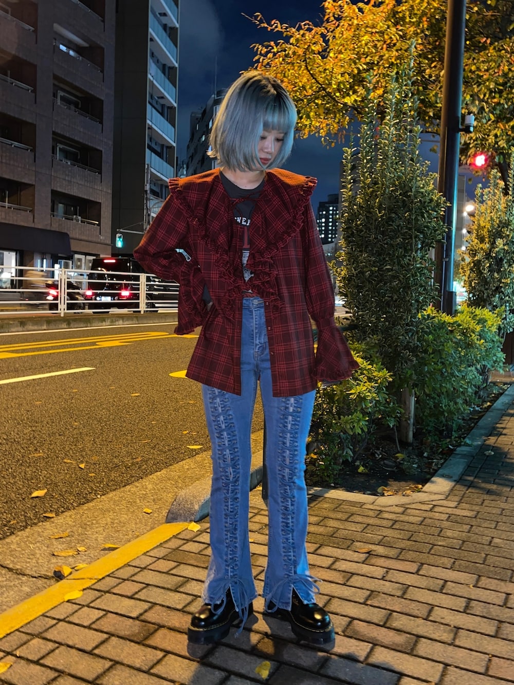 レッド系のシャツ/ブラウス、ブラック系のTシャツ/カットソー、ブルー系のデニムパンツを着用したレディースの秋コーディネートの3枚目の写真