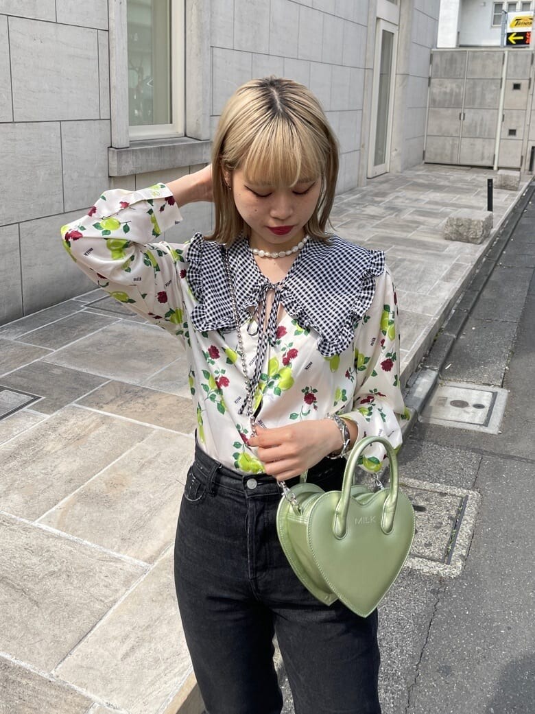 ブラック系のデニムパンツ、ホワイト系のシャツ/ブラウス、グリーン系のショルダーバッグを着用したレディースの春コーディネートの4枚目の写真