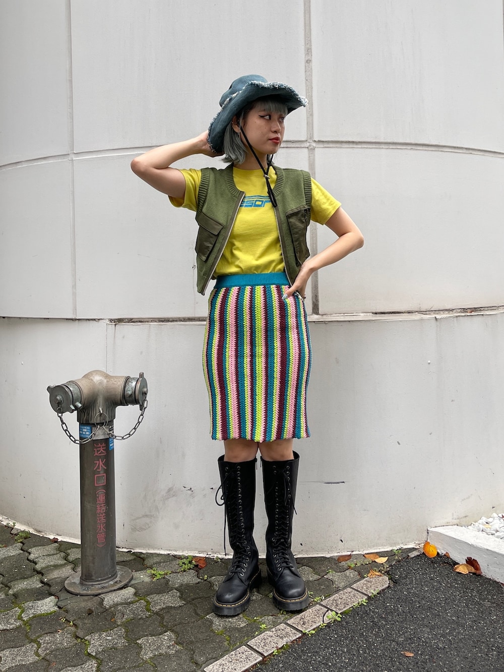 イエロー系のTシャツ/カットソー、グリーン系のベスト、ブルー系のスカートを着用したレディースの春コーディネートの2枚目の写真