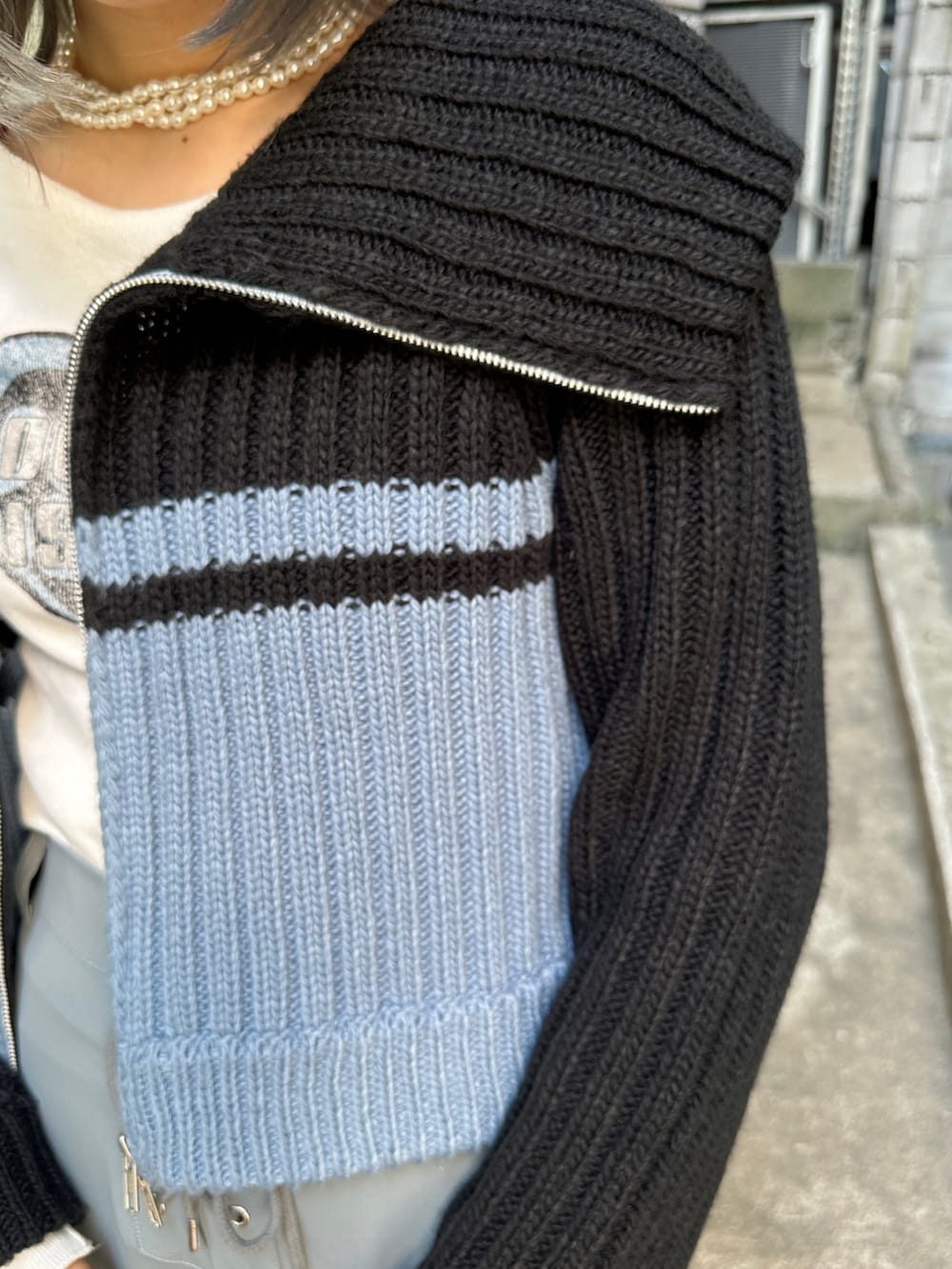 グレー系のその他パンツ、ホワイト系のTシャツ/カットソー、ブラック系のニット/セーターを着用したレディースの秋コーディネートの9枚目の写真