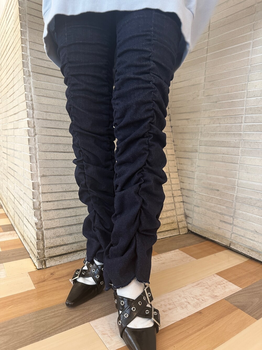 ブルー系のスウェット、ブラック系のパンプス、ブルー系のデニムパンツを着用したレディースの秋コーディネートの8枚目の写真