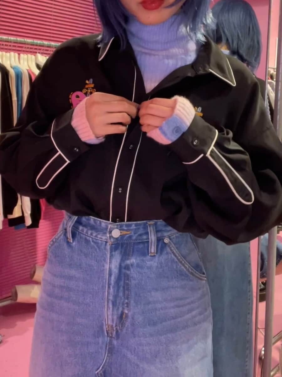 ブルー系のスカート、ブラック系のブーツ、ブラック系のシャツ/ブラウスを着用したレディースの秋コーディネートの2枚目の写真