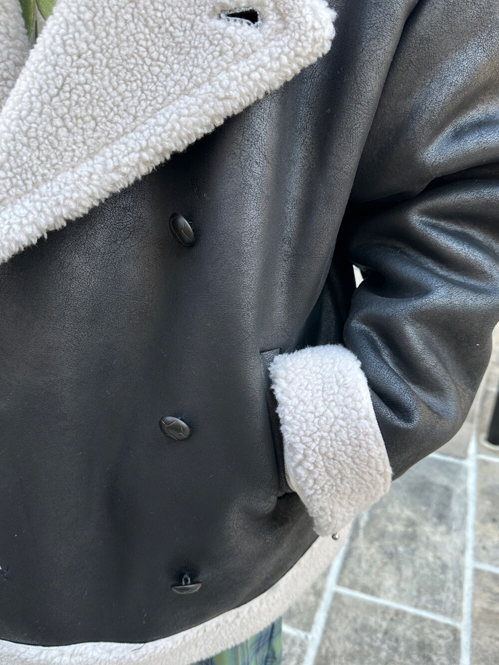 ブラック系のムートンコート、グレー系のスウェット、グリーン系のワンピースを着用したレディースの冬コーディネートの7枚目の写真