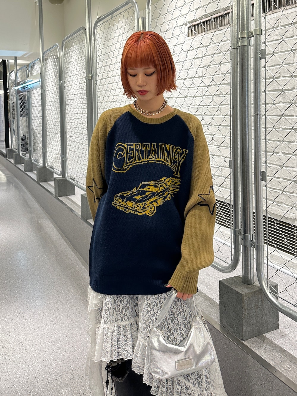 ブルー系のニット/セーター、ホワイト系のスカート、ブラック系のデニムパンツを着用したレディースの冬コーディネートの6枚目の写真