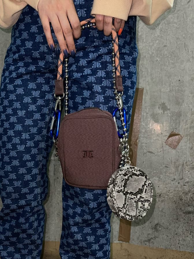 ブラウン系のショルダーバッグ、ベージュ系のTシャツ/カットソー、ブルー系のデニムパンツを着用したレディースの秋コーディネートの8枚目の写真