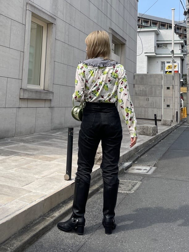 ブラック系のデニムパンツ、ホワイト系のシャツ/ブラウス、グリーン系のショルダーバッグを着用したレディースの春コーディネートの2枚目の写真