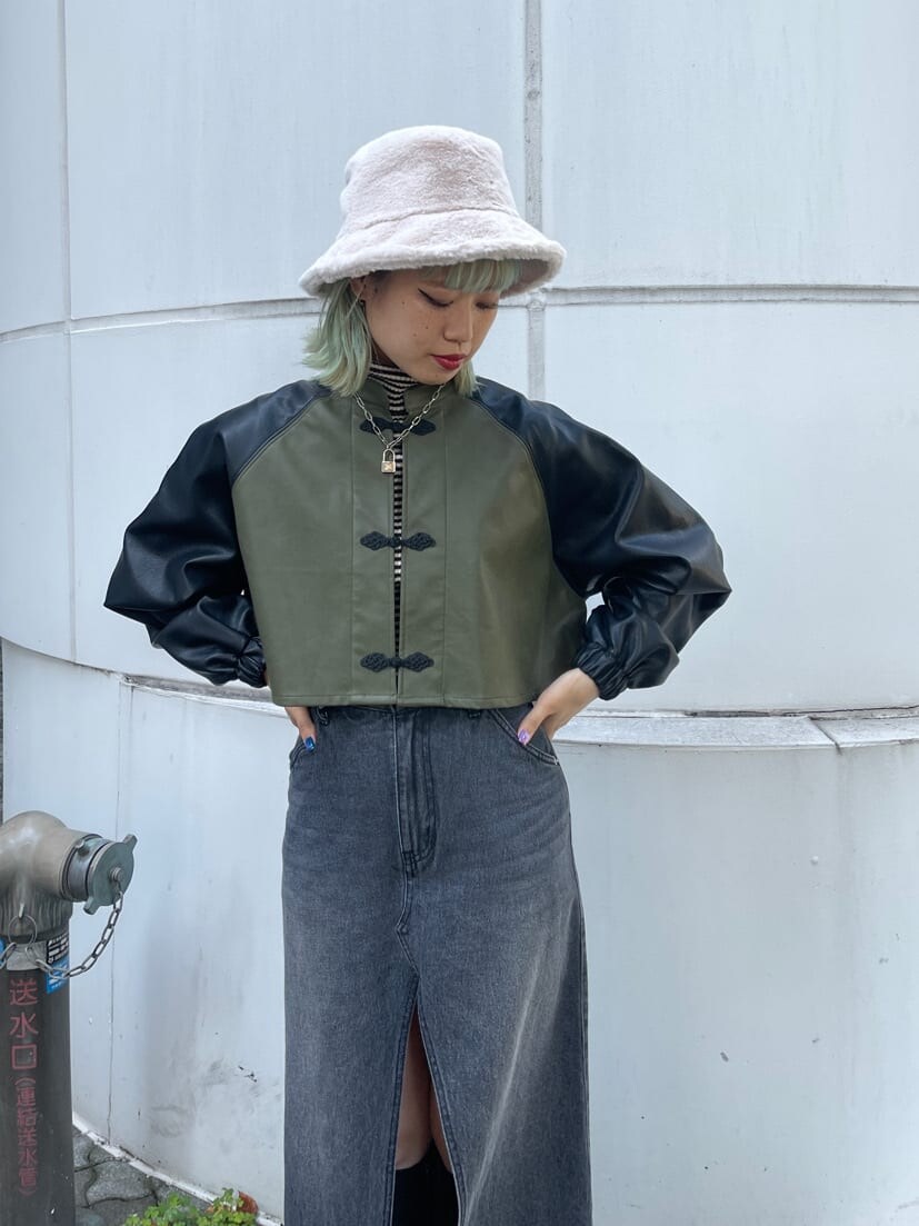 ブラック系のブーツ、ブラック系のスカート、ホワイト系のニット/セーターを着用したレディースの秋コーディネートの4枚目の写真