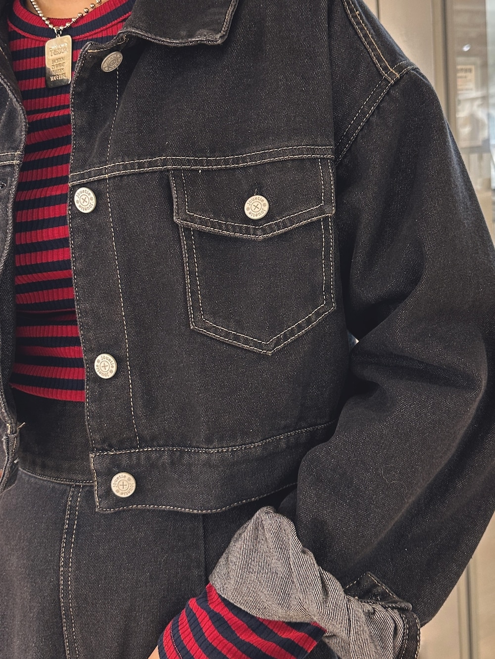 レッド系のTシャツ/カットソー、ブラック系のワンピース、ブラック系のブーツを着用したレディースの夏コーディネートの7枚目の写真