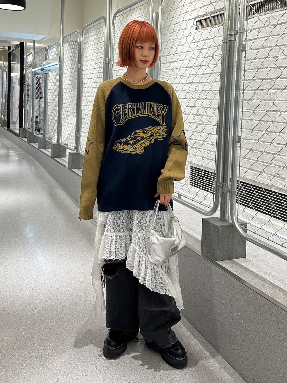 ブルー系のニット/セーター、ホワイト系のスカート、ブラック系のデニムパンツを着用したレディースの冬コーディネートの2枚目の写真