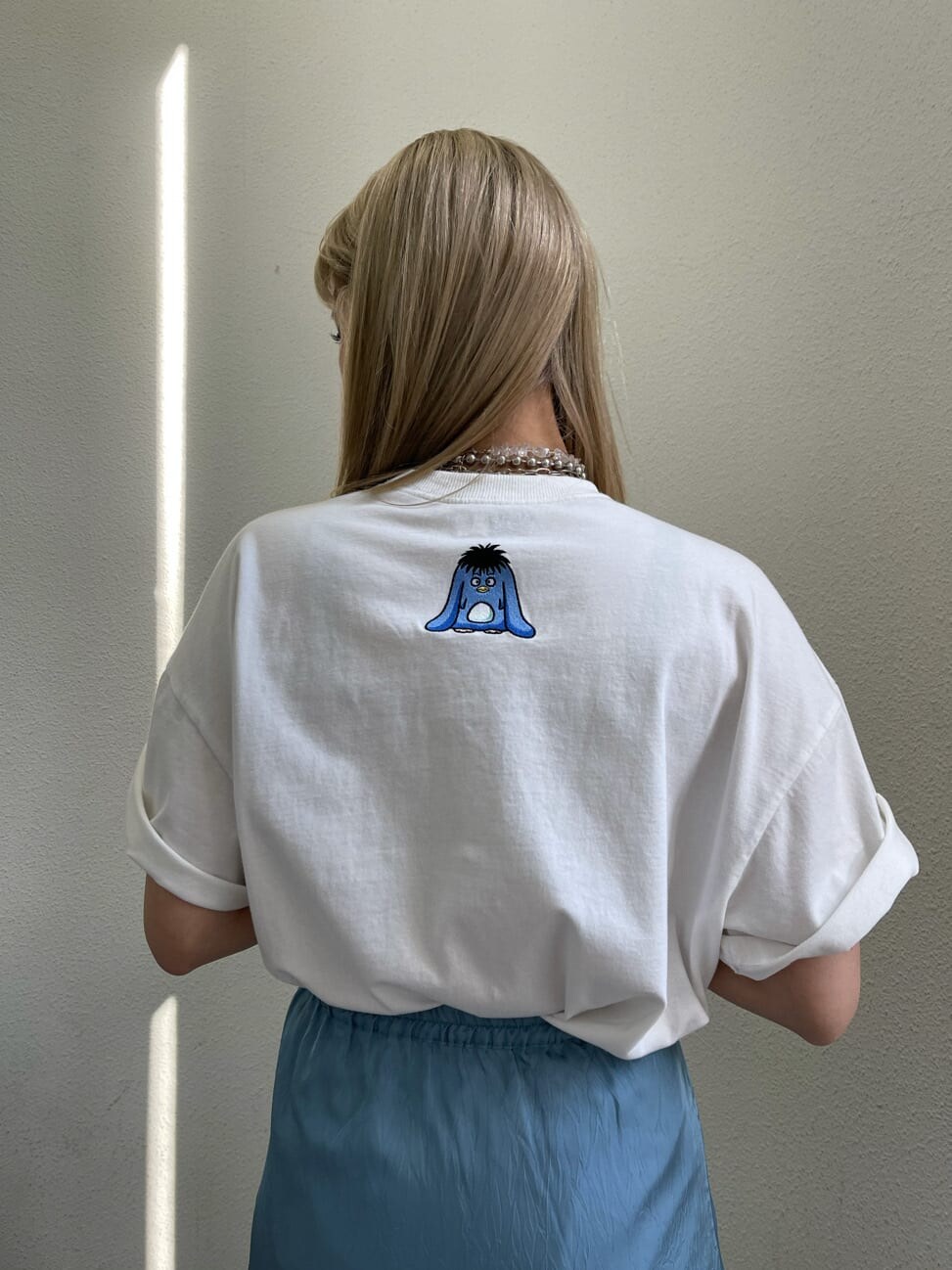 ブルー系のスカート、ホワイト系のTシャツ/カットソーを着用したレディースの夏コーディネートの4枚目の写真