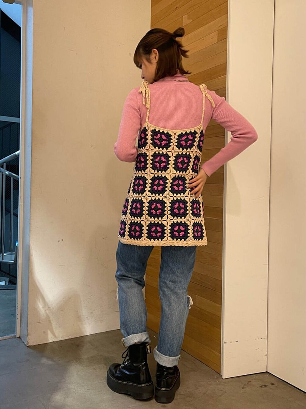 ブルー系のデニムパンツ、ピンク系のニット/セーター、ホワイト系のキャミソールを着用したレディースの冬コーディネートの2枚目の写真