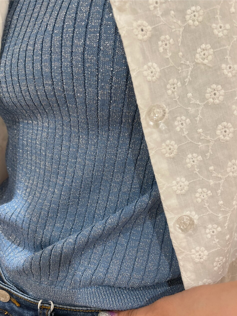 ブラック系のブーツ、ホワイト系のワンピース、ブルー系のデニムパンツを着用したレディースの春コーディネートの5枚目の写真