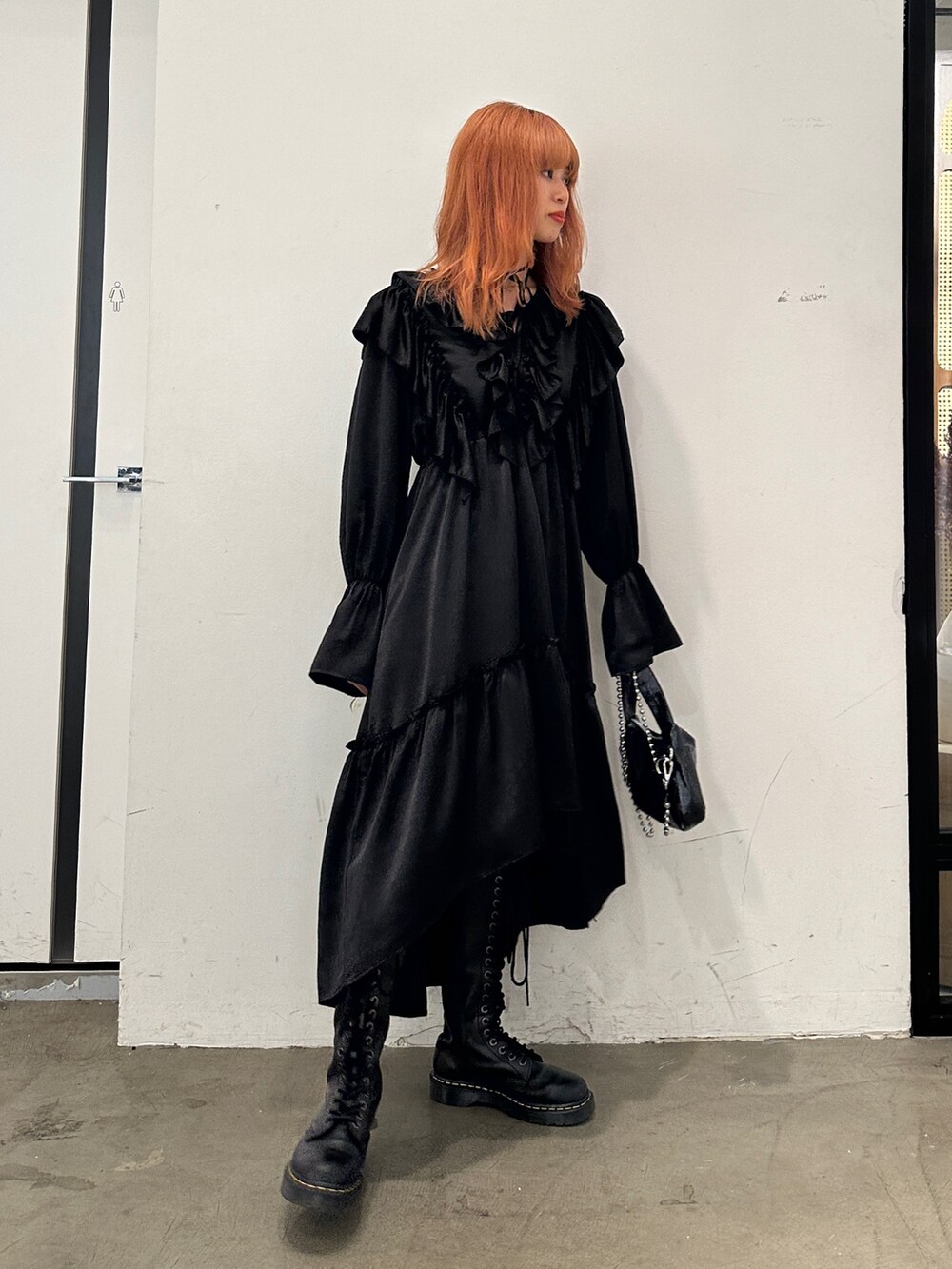 ブラック系のワンピース、ブラック系のハンドバッグ、ブラック系のブーツを着用したレディースの秋コーディネートの4枚目の写真