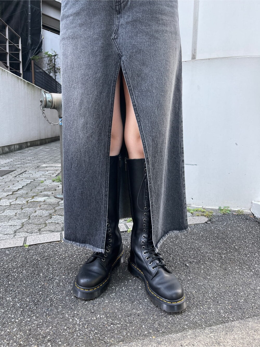 ブラック系のブーツ、ブラック系のスカート、ホワイト系のニット/セーターを着用したレディースの秋コーディネートの6枚目の写真