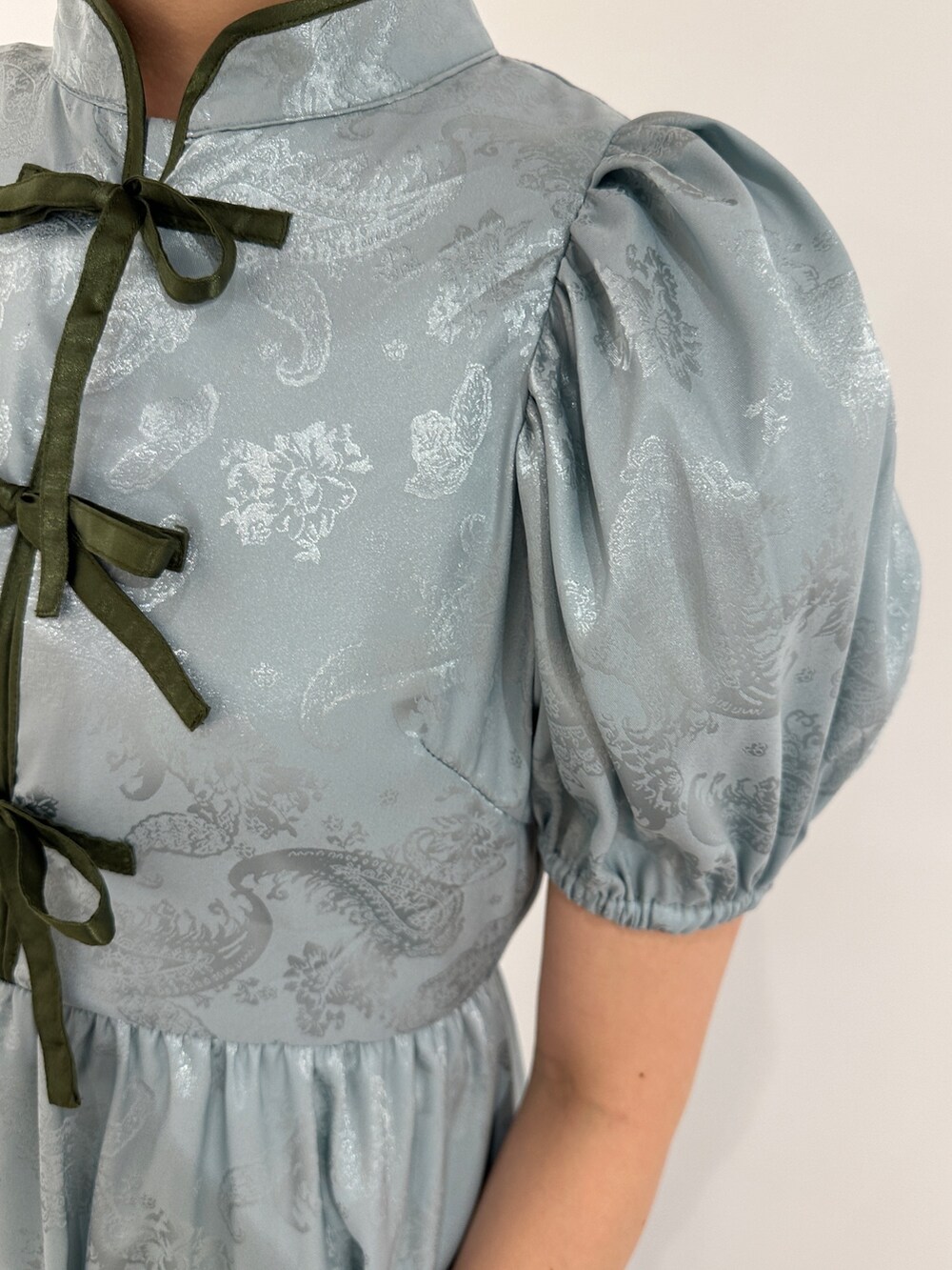 ブルー系のワンピース、ブラック系のブーツを着用したレディースの春コーディネートの6枚目の写真