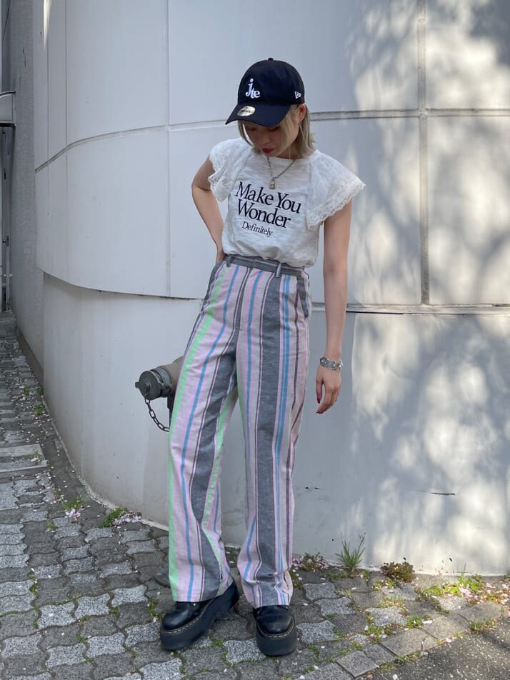 ブラック系のその他シューズ、ブラック系のスラックス、ホワイト系のTシャツ/カットソーを着用したレディースの春コーディネートの3枚目の写真