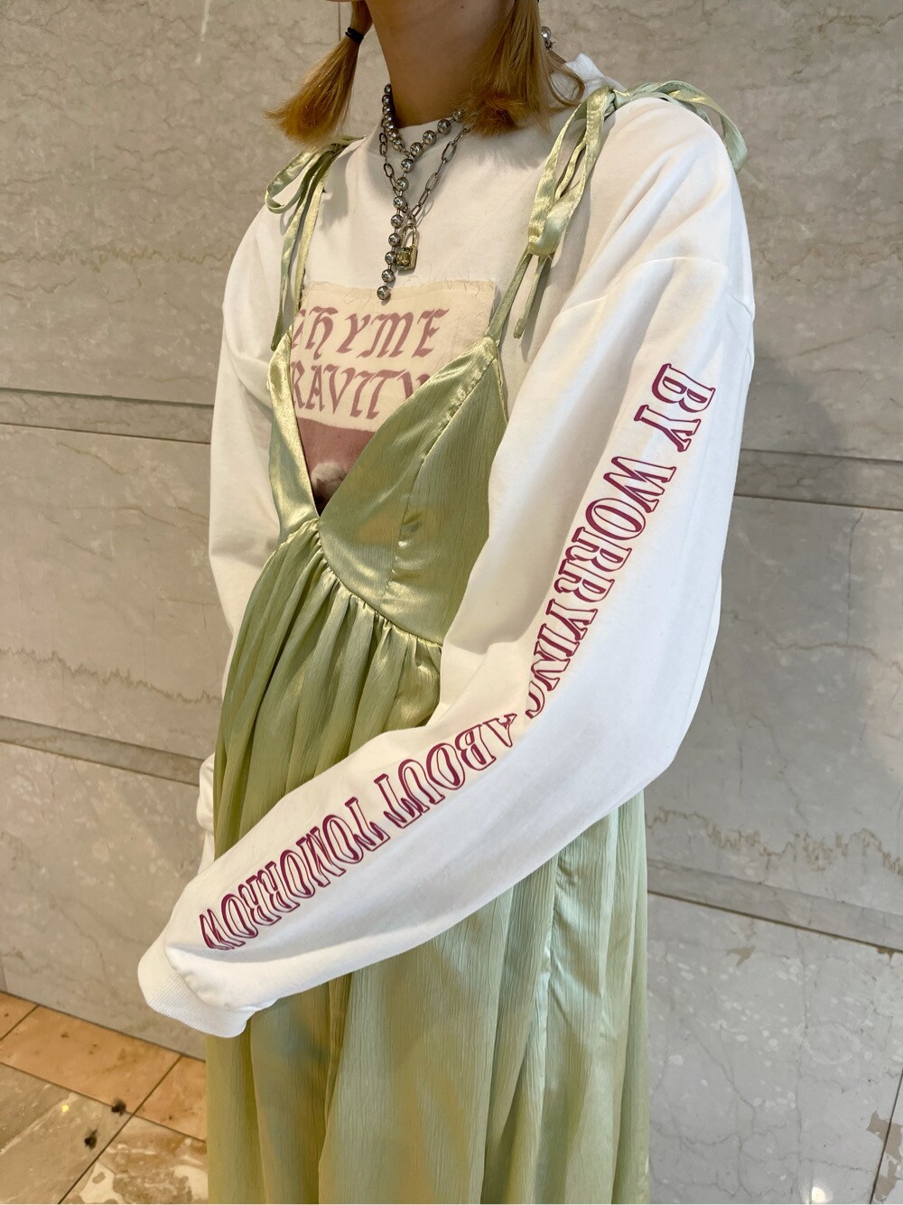 グリーン系のワンピース、ホワイト系のTシャツ/カットソー、ブルー系のデニムパンツを着用したレディースの春コーディネートの3枚目の写真