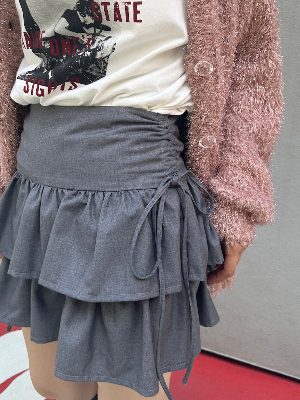 グレー系のスカート、ブラック系のブーツ、ホワイト系のTシャツ/カットソーを着用したレディースの夏コーディネートの8枚目の写真