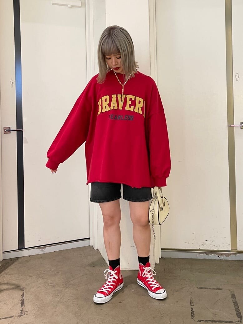 レッド系のスニーカー、ブラック系のデニムパンツ、レッド系のスウェットを着用したレディースの春コーディネートの2枚目の写真