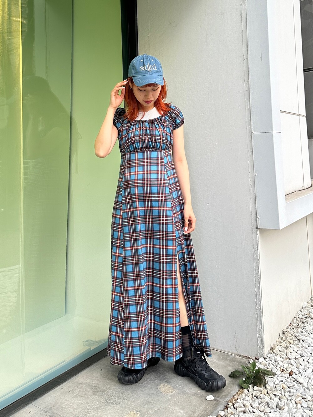 ブルー系のワンピース、ブラック系のスニーカー、ブルー系のキャップを着用したレディースの春コーディネートの4枚目の写真