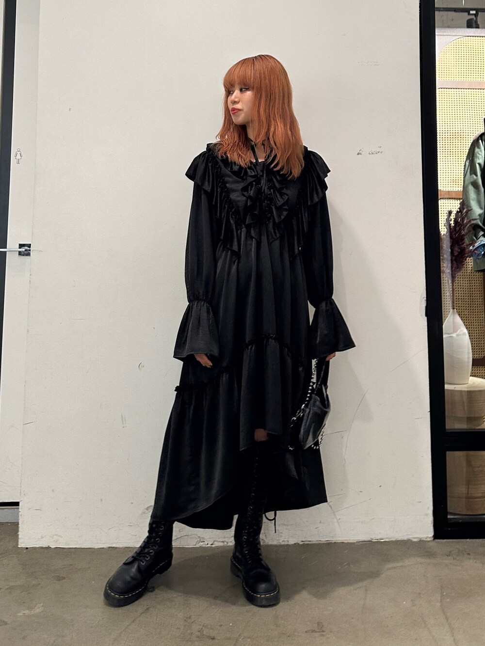 ブラック系のワンピース、ブラック系のハンドバッグ、ブラック系のブーツを着用したレディースの秋コーディネートの5枚目の写真