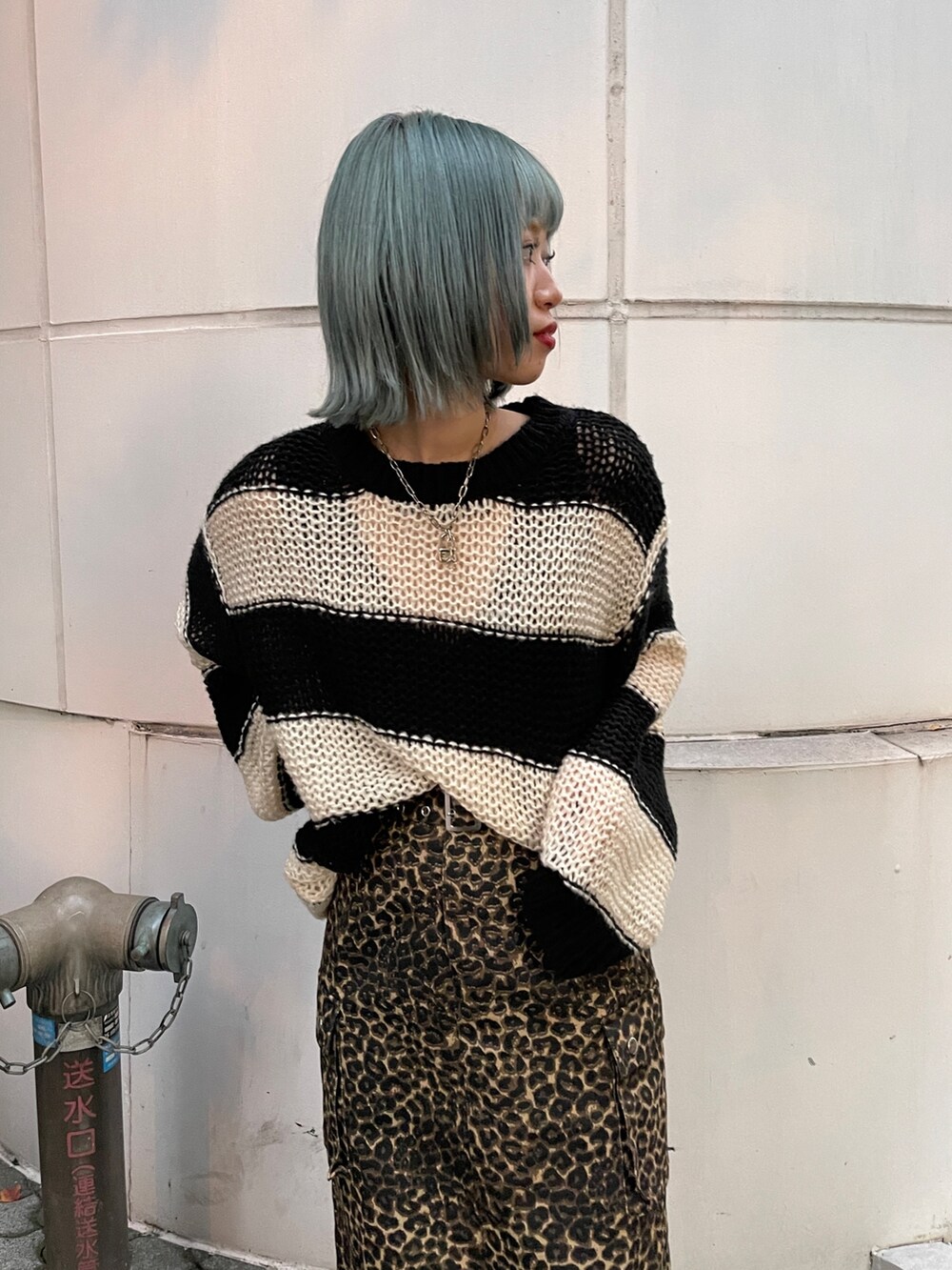 ブラウン系のスカート、ブラック系のニット/セーター、ブラック系のスニーカーを着用したレディースの秋コーディネートの4枚目の写真